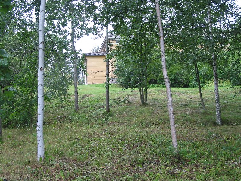 Kuva: Pappilanmäen kalmistoa kuvattuna W.  Taustalla näkyy pappilan päärakennus. Leena Koivisto 18.8.2004